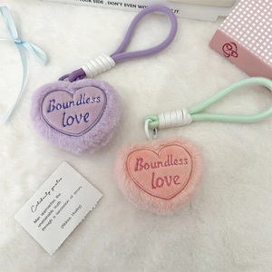 Detail of plush heart keychains in purple and pink with Boundless love embroidery