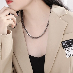 Close-up of geometric square link chain necklace in silver finish worn by a model