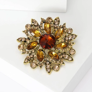 Macro detail of retro sunflower brooch with colorful crystals and gold metal finish