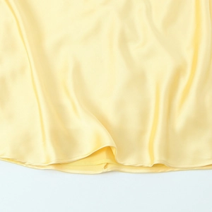 Détail de robe jaune clair en ramie mélangée avec ourlet satiné et coutures fines
