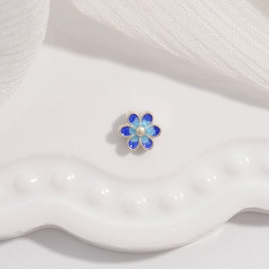 Vue macro d'une perle fleur en émail bleu avec bords argentés pour bijoux DIY
