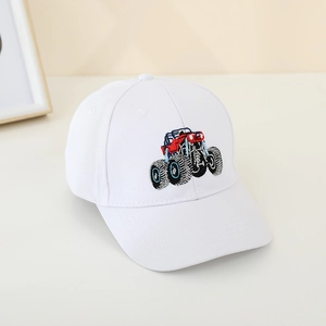 Detail shot of a white kids baseball cap featuring an embroidered off-road monster truck