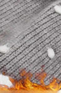Detail of grey knitted fabric texture with soft white faux fur pompom on kid's winter hat