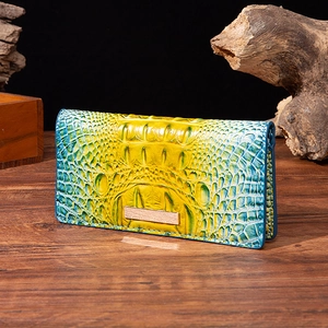 Detail of gradient crocodile embossed long leather wallet with gold metal accent