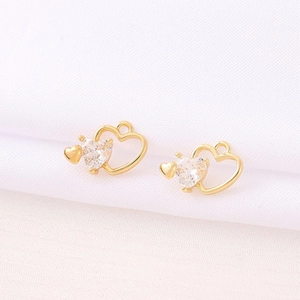Detailed close-up of golden hollow heart pendants with sparkling cubic zirconia crystals