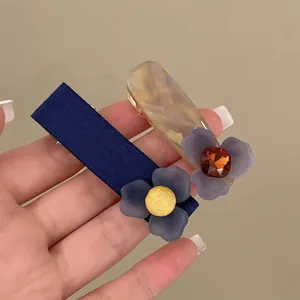 Set di fermagli per capelli con fiori in tessuto blu e resina marmorizzata chic