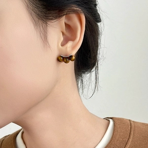 Minimalist tiger eye stone stud earrings with silver pins worn on model in retro style