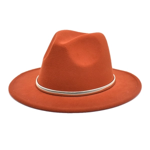 Detail of burnt orange wool fedora hat featuring a slim gold metal decorative band
