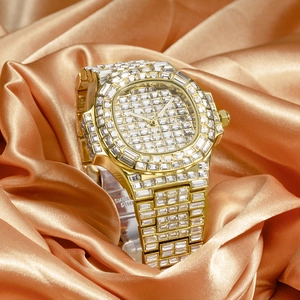 Detailed close-up of a gold luxury diamond watch resting on premium orange silk fabric