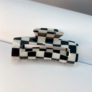 Macro shot of large black and white checkerboard hair claw clip with glossy finish