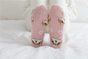 Detail of pink coral fleece socks showing soft plush texture and cute cartoon cat pattern