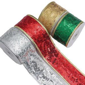 Detail of sequined Christmas ribbons in red, gold, silver and green on rolls