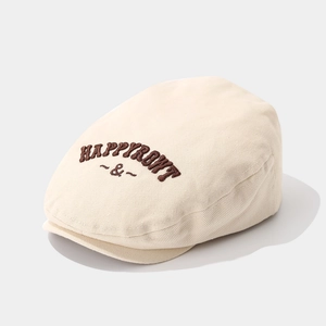 Détail d'une casquette beige pour bébé avec broderie HAPPY marron et texture en sergé