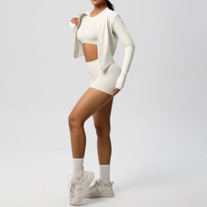 Vista laterale del set fitness 3 pezzi avorio con reggiseno sportivo, pantaloncini e giacca