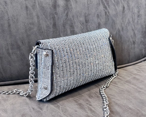 Detail of silver rhinestone evening bag with black trim and chunky metallic chain strap
