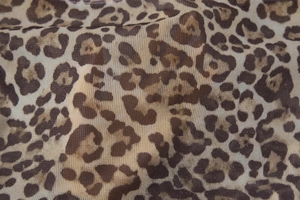 Close-up of leopard print fabric with metallic glitter and fine mesh knitting details