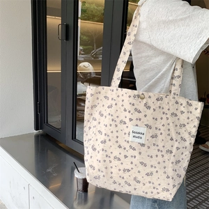 Detail of vintage floral canvas tote bag with magnetic clasp and branded fabric label