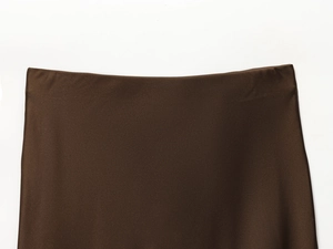 Detail of the high-waist band on a brown satin midi skirt with smooth silky texture