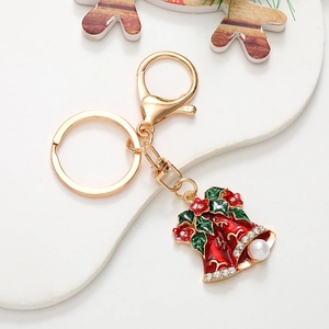 Detail of Christmas bell keychain with green leaves, red flowers, and crystal accents