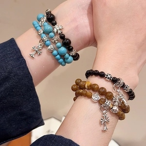 Détail de bracelets en perles de pierre avec pendentifs en forme de croix vintage