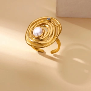Detailed close-up of a golden multi-layer spiral ring featuring a pearl and blue gemstone