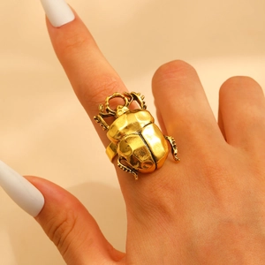 Close-up of a vintage gold beetle ring showing intricate insect details and metallic texture