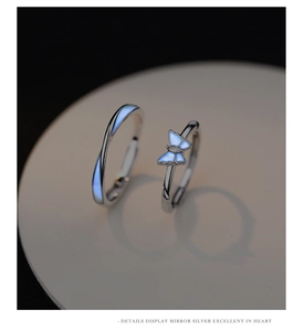 Detailed close-up of luminous butterfly silver rings featuring glowing blue enamel elements