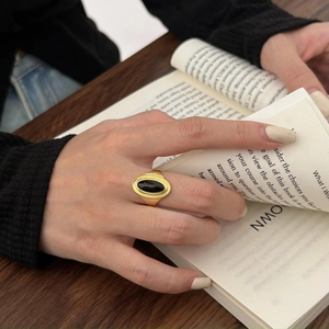 Retro 925 sterling silver ring with oval black agate on a vintage book background