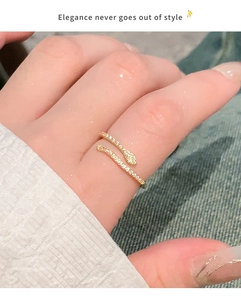 Close-up of elegant gold snake open ring with cubic zirconia paving on finger