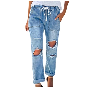 Detail of light wash ripped jeans featuring elastic drawstring waist and large cargo pockets