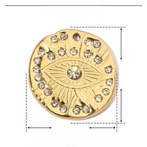 Detail of 18k gold plated evil eye pendant in stainless steel with rhinestones