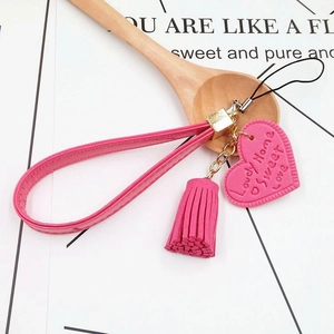 Pink leather heart keychain with tassels and Lovely Home print on a white background