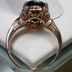 Macro view of vintage gold ring featuring intricate filigree and a large heart black stone