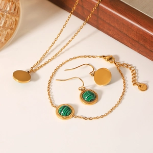 Close-up of gold stainless steel jewelry set featuring polished green malachite stones