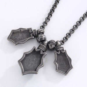 Close-up of vintage silver necklace with triple shield pendants and hexagonal metal beads