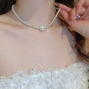 Silver woven choker necklace with round white pearl pendant worn on model neck