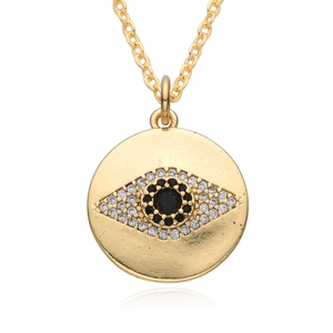 Macro shot of 18K gold evil eye coin pendant with black and white zircon stone inlay