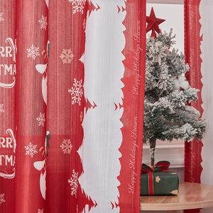 Detail of red Christmas curtain fabric with white snowflakes and festive lettering prints