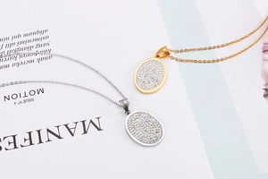 Close-up of gold and silver plated oval pendants with pave-set zircon on sleek chains