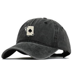 Detail of playing cards embroidery on a vintage washed cotton baseball cap with a worn look