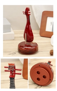 Detail view of vintage Pipa music box with faux wood finish and rotating base