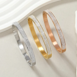 Detailed shot of triple-row rhinestone bangles in silver, gold, and rose gold steel