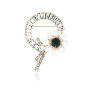 Elegant floral pearl brooch with green gems and crystals on golden circle frame