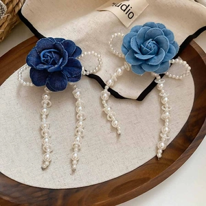 Detailed shot of denim flower hair clips with pearl tassels and beads in blue shades