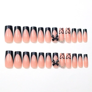 Long coffin press-on nails with black French tips, bows, and sparkling rhinestones