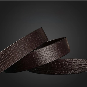 Detailed macro view of dark brown genuine cowhide leather belt with embossed crocodile pattern