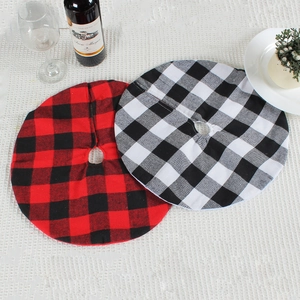 Classic red and white buffalo plaid Christmas tree skirts displayed on a table
