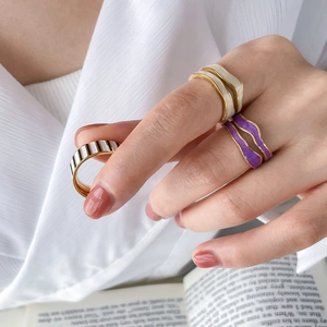 Three geometric colorful enamel rings in gold finish with striped and wavy patterns
