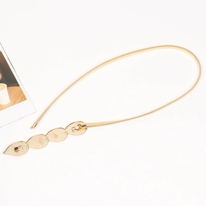 Detail of gold elastic metal belt with leaf shaped buckle for dresses and accessories