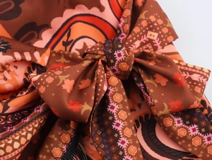 Detailed macro view of the ethnic knot tie and bohemian paisley print on this mini skirt
